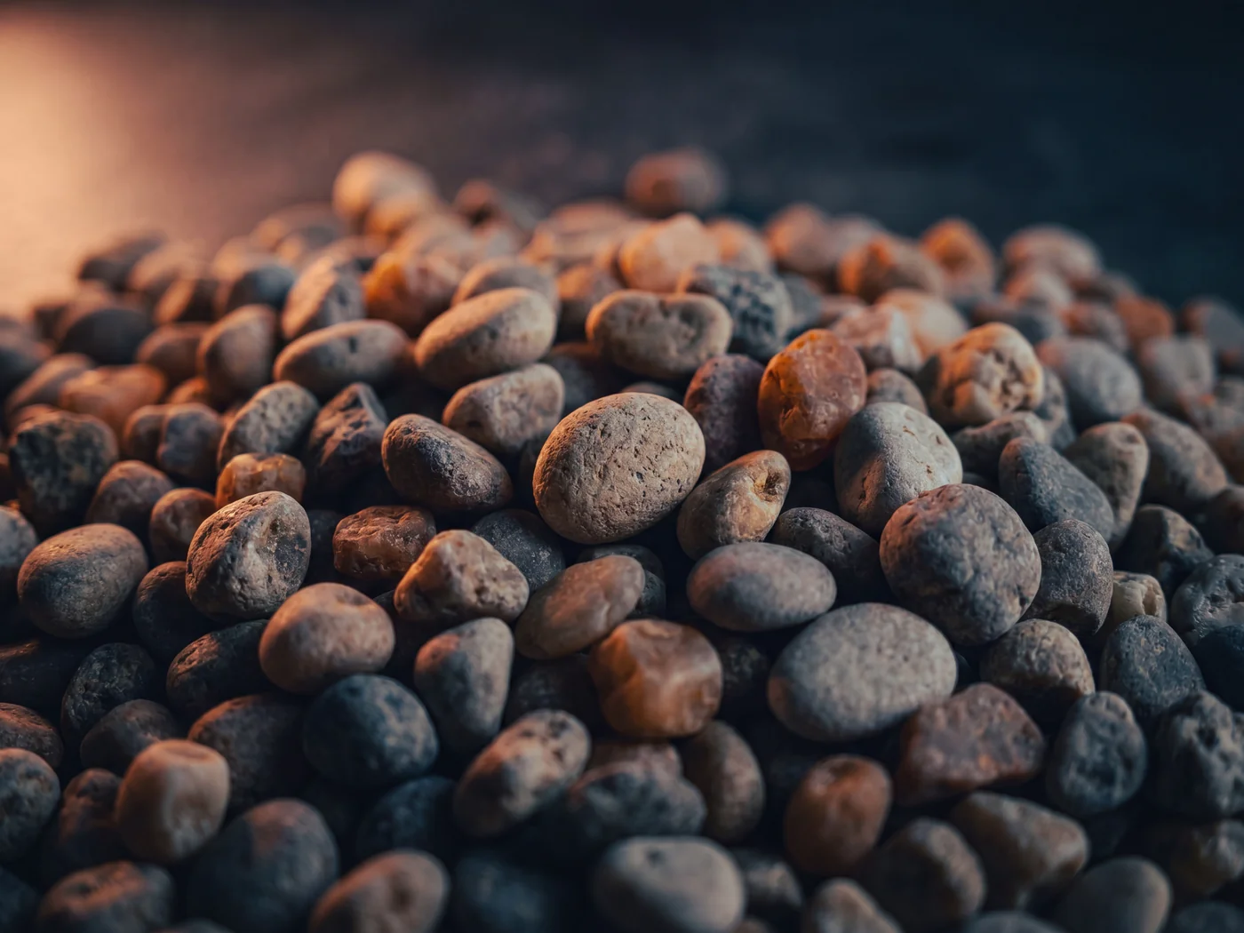 Close up of clean rounded pea gravel, small smooth pebbles catching soft light