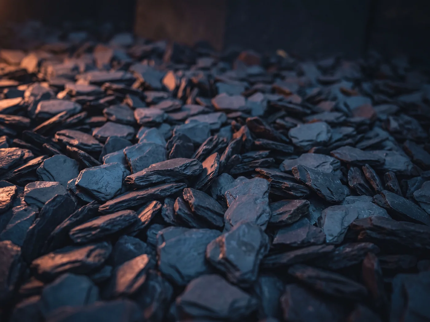Close up of deep blue grey slate chippings, flat angular pieces with a rich sheen